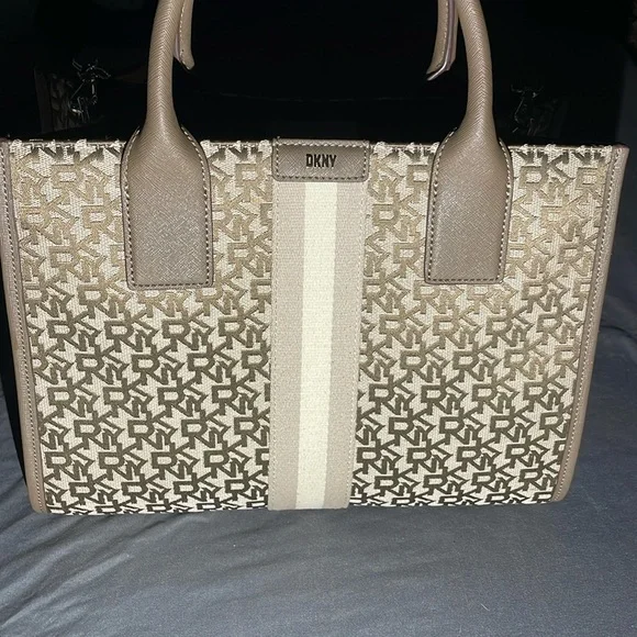 This bag is Tan and brown with a strap, one zipper, two pockets, space inside.